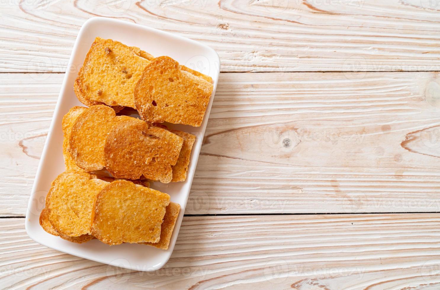 gebackenes knuspriges Brot mit Butter und Zucker auf Teller foto