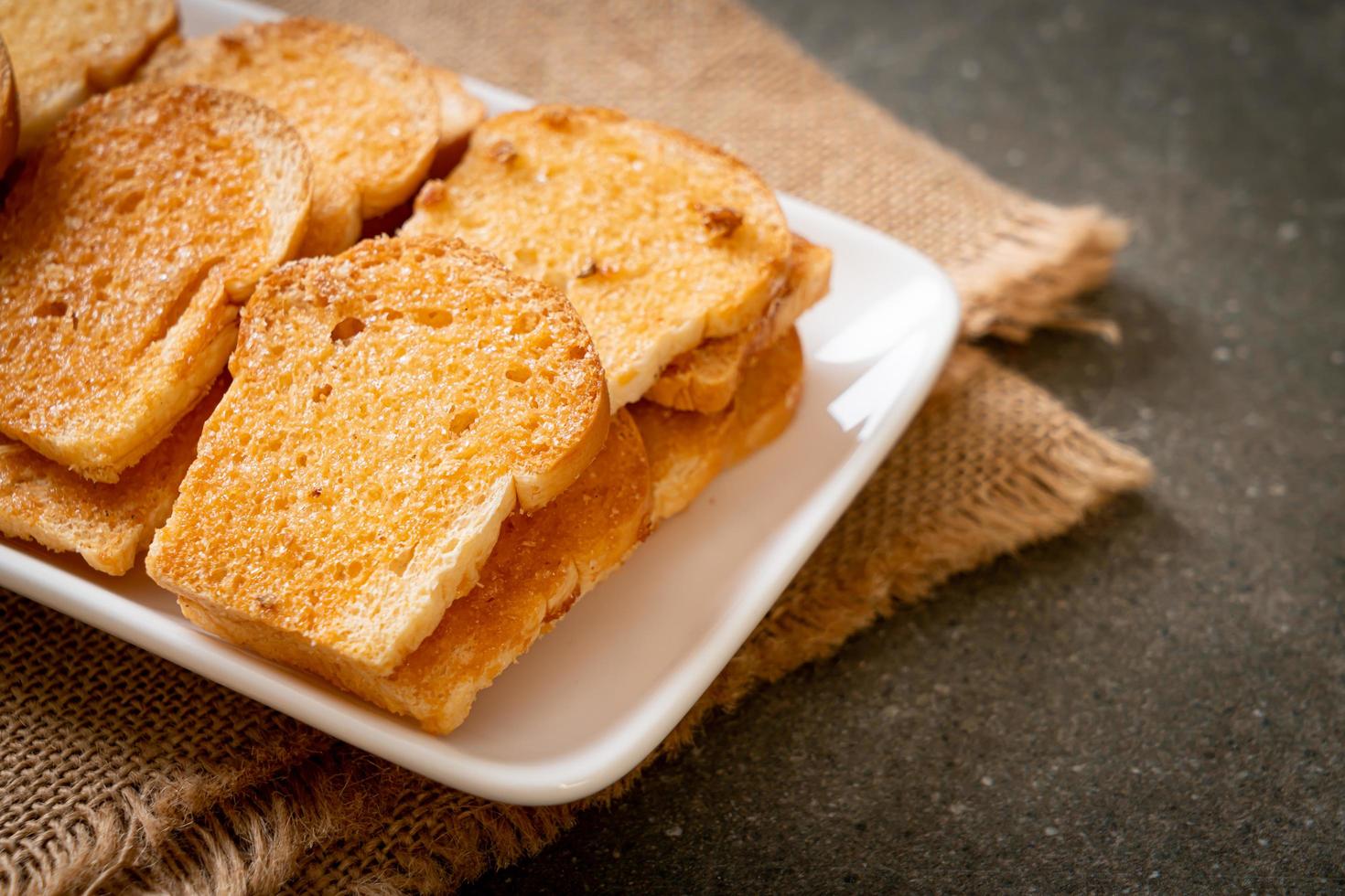 gebackenes knuspriges Brot mit Butter und Zucker auf Teller foto