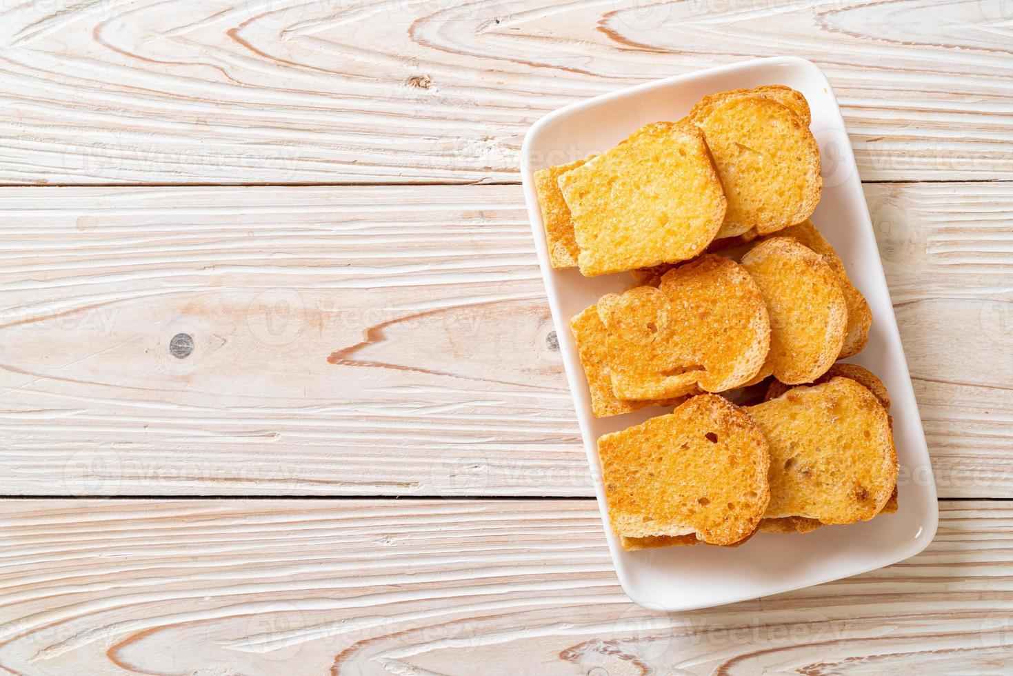 gebackenes knuspriges Brot mit Butter und Zucker auf Teller foto