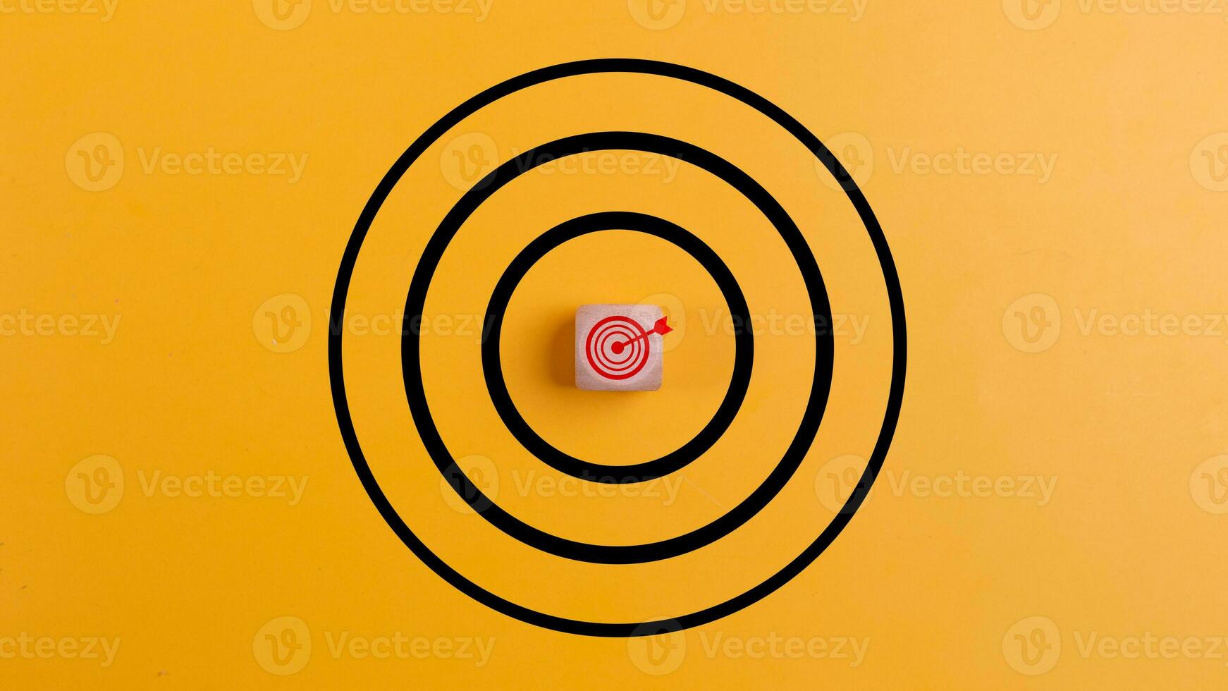 Konzept von Erfolg. Ziel mit ein Ziel Symbol auf ein hölzern Block auf ein Gelb Hintergrund das Konzept von erreichen oder Targeting Geschäft Ziele. foto
