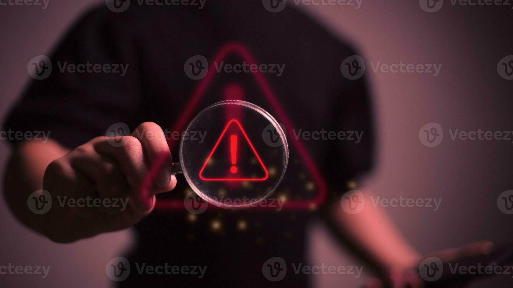Hand halten Lupe Glas mit rot Dreieck Vorsicht Warnung Zeichen zum Fokus Benachrichtigung Error und Instandhaltung Konzept. foto