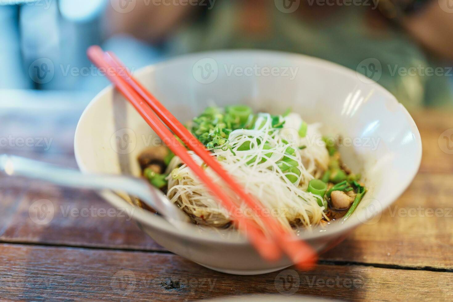 thailändisch Boot Nudel verdicken Suppe mit Schweinefleisch, Bälle, knusprig gebraten Schweinefleisch Haut, Basilikum Blatt und Gemüse. traditionell und berühmt Straße Essen im Thailand foto