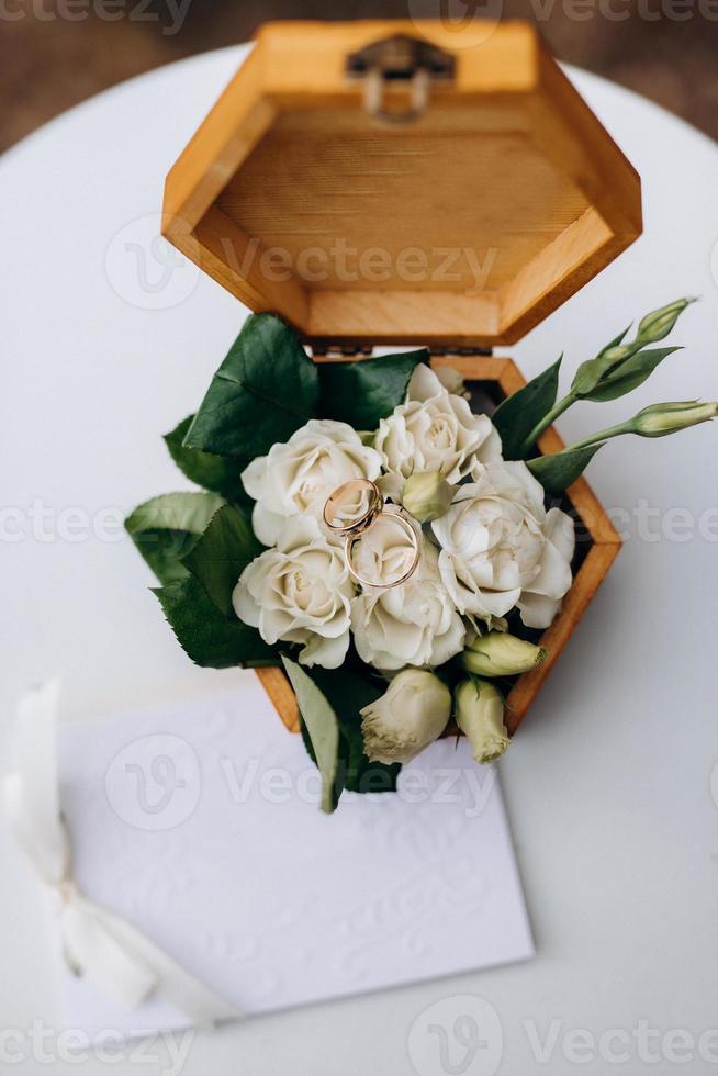 goldene Eheringe mit einer Hochzeitsdekoration foto