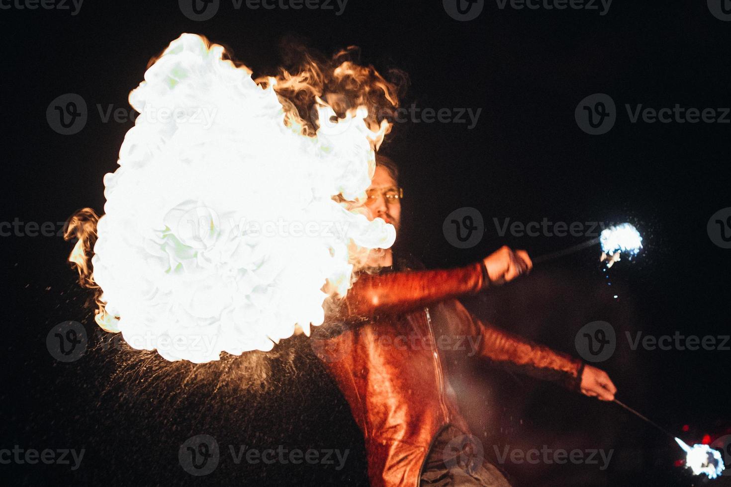 die nächtliche Feuershow unter Beteiligung der Menschen anzünden, anzünden und offenes Feuer foto