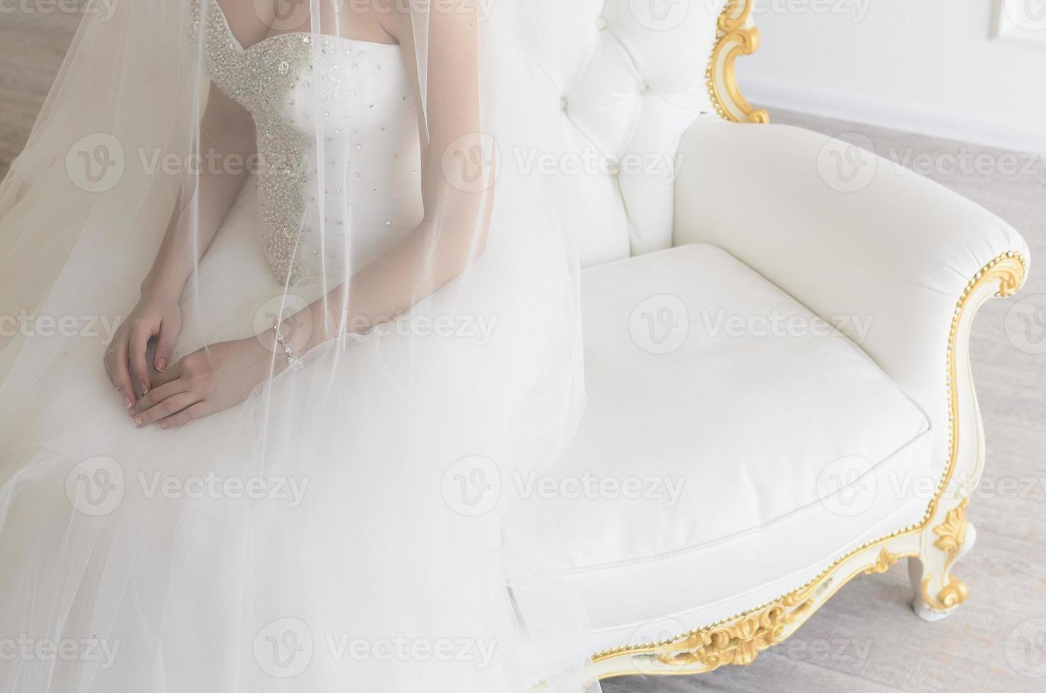 die Braut auf einem weißen Stuhl foto
