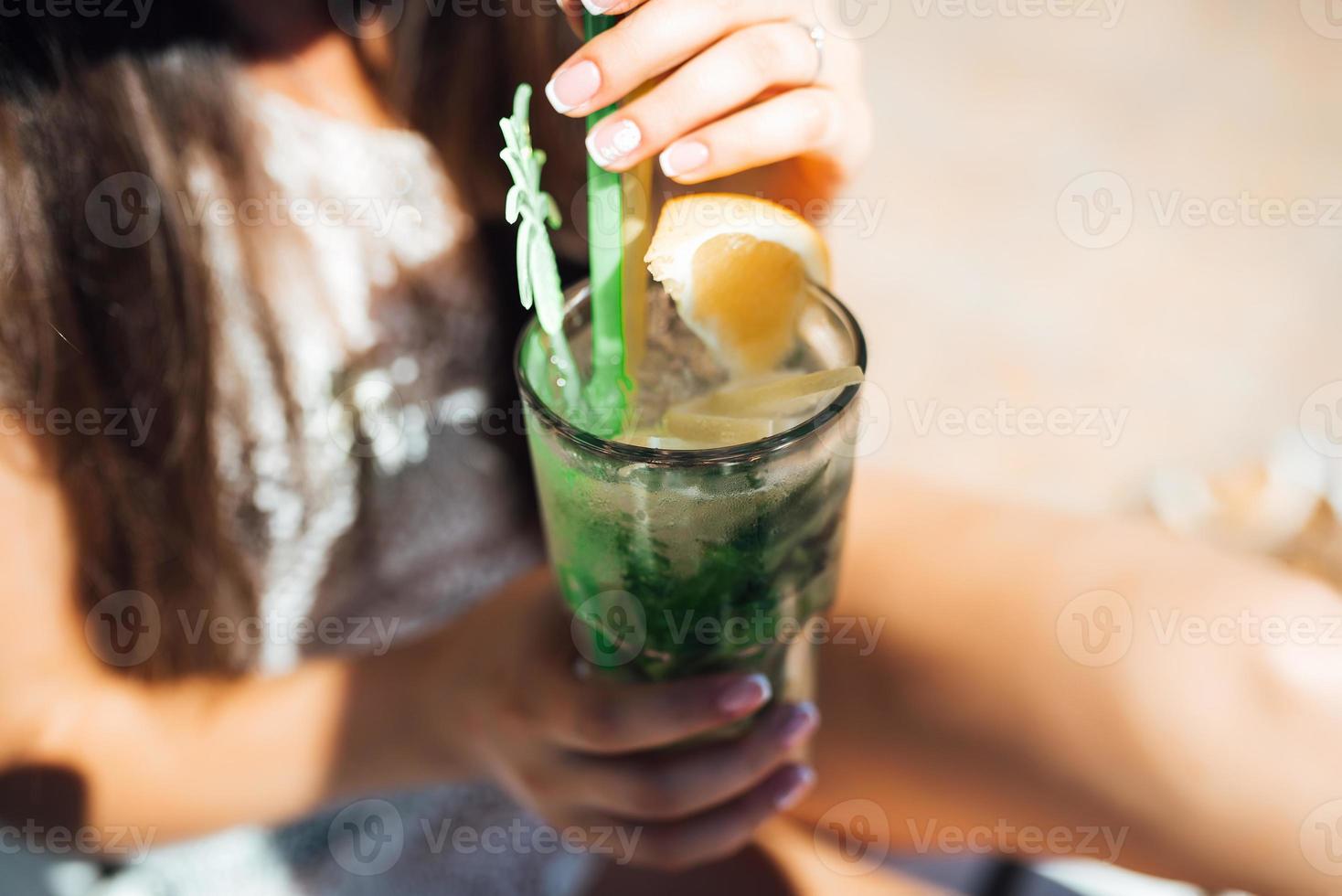 Mädchen ist ein Getränk-Fruchtalkohol-Cocktail auf der Basis von Limette, Minze, Orange, Soda foto