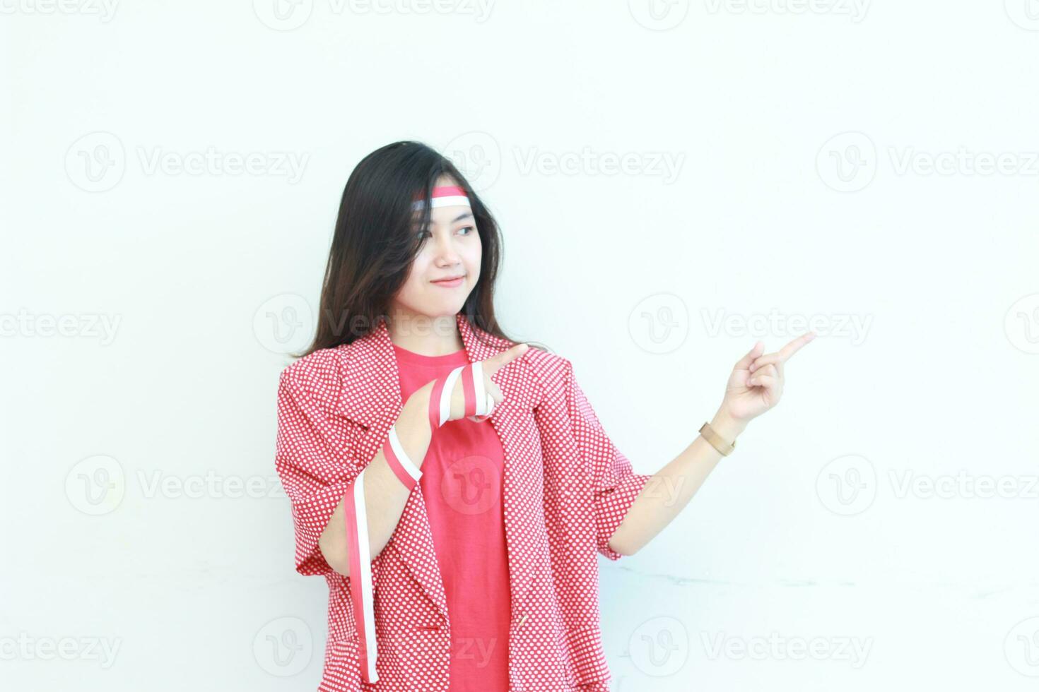Porträt von schön asiatisch Frau tragen rot Outfit zum feiern Unabhängigkeit Tag zeigen zu das Seite zum Kopieren Raum foto