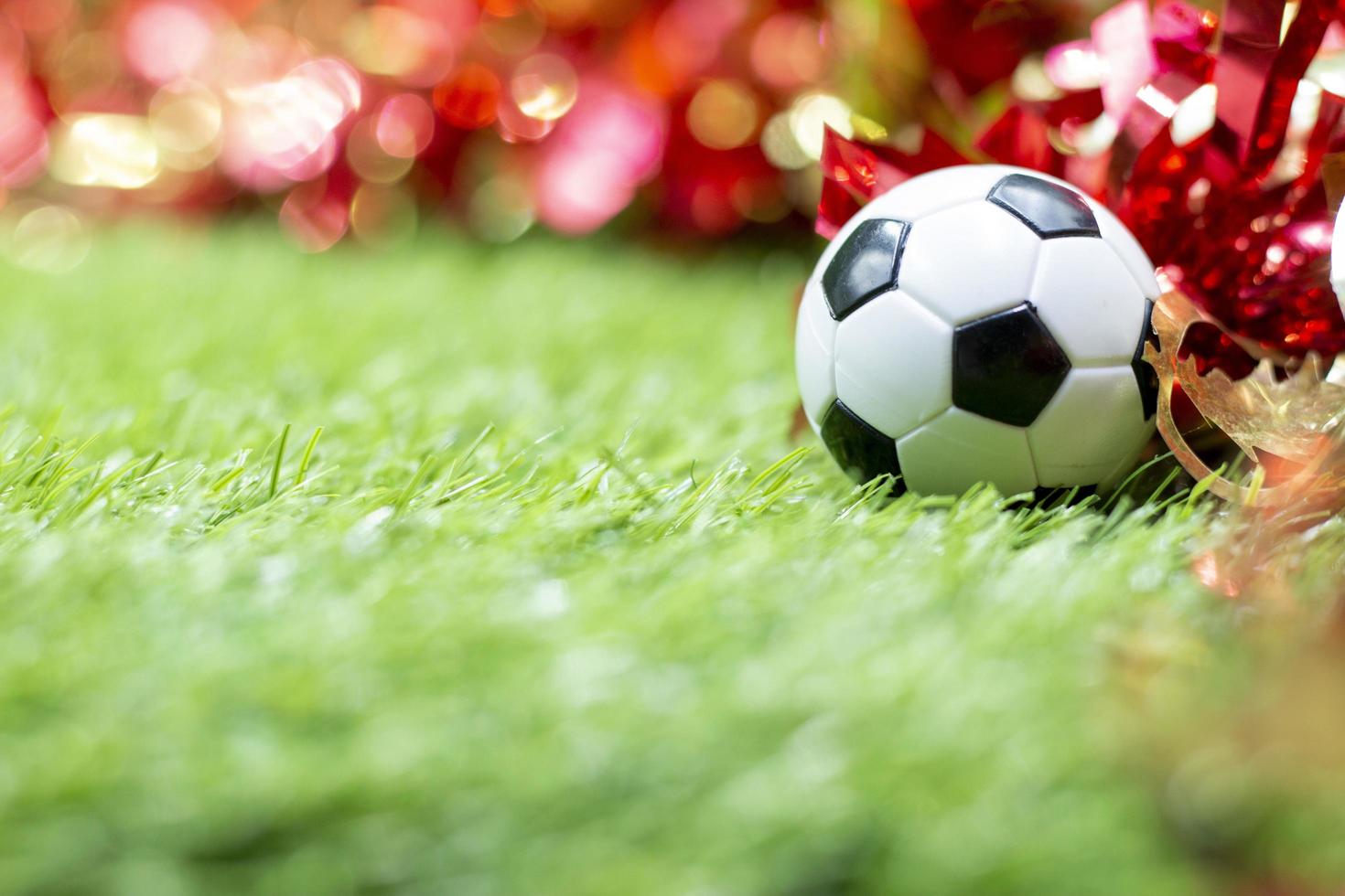 Fußball mit Weihnachtsdekoration auf grünem Gras foto