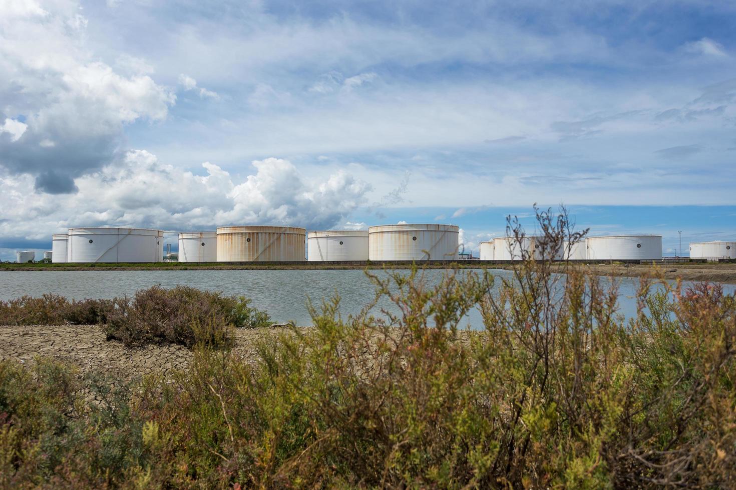 Öltanks in Folge unter blauem Himmel, großer weißer Industrietank für Benzin, Ölraffinerieanlage. Energie und Kraft foto