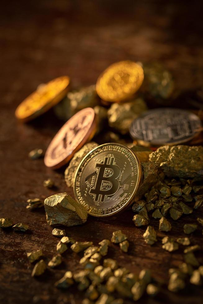 Gold-Bitcoin physische Bitcoin-Kryptowährung und Goldnugget-Körner. foto