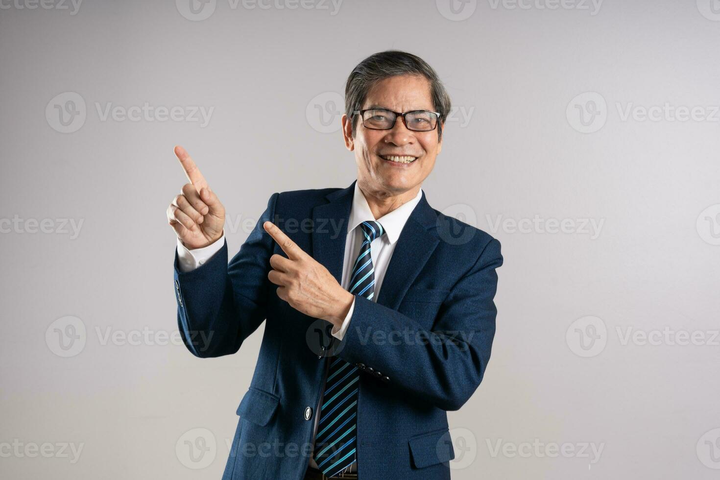 Porträt von ein Alten asiatisch Geschäftsmann, posieren auf ein Blau Hintergrund foto