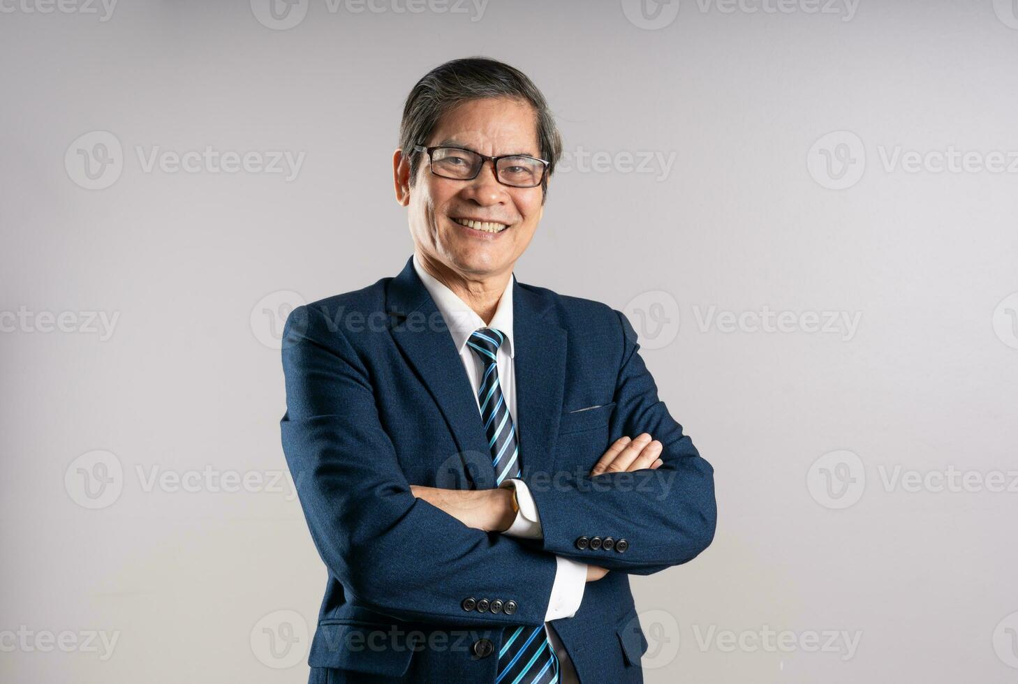 Porträt von ein Alten asiatisch Geschäftsmann, posieren auf ein Blau Hintergrund foto