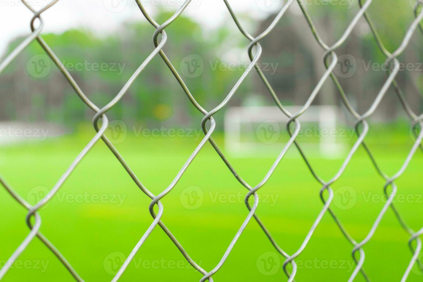 ein Fußball Feld Aussicht von draußen das Zaun, Fokussierung auf das Zaun. nach etwas bearbeitet. foto