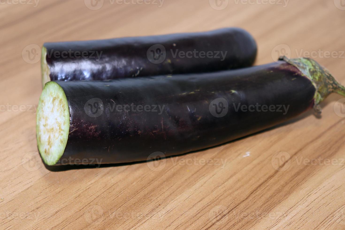 Violett gefärbter Brinjal auf Holztisch zum Kochen foto