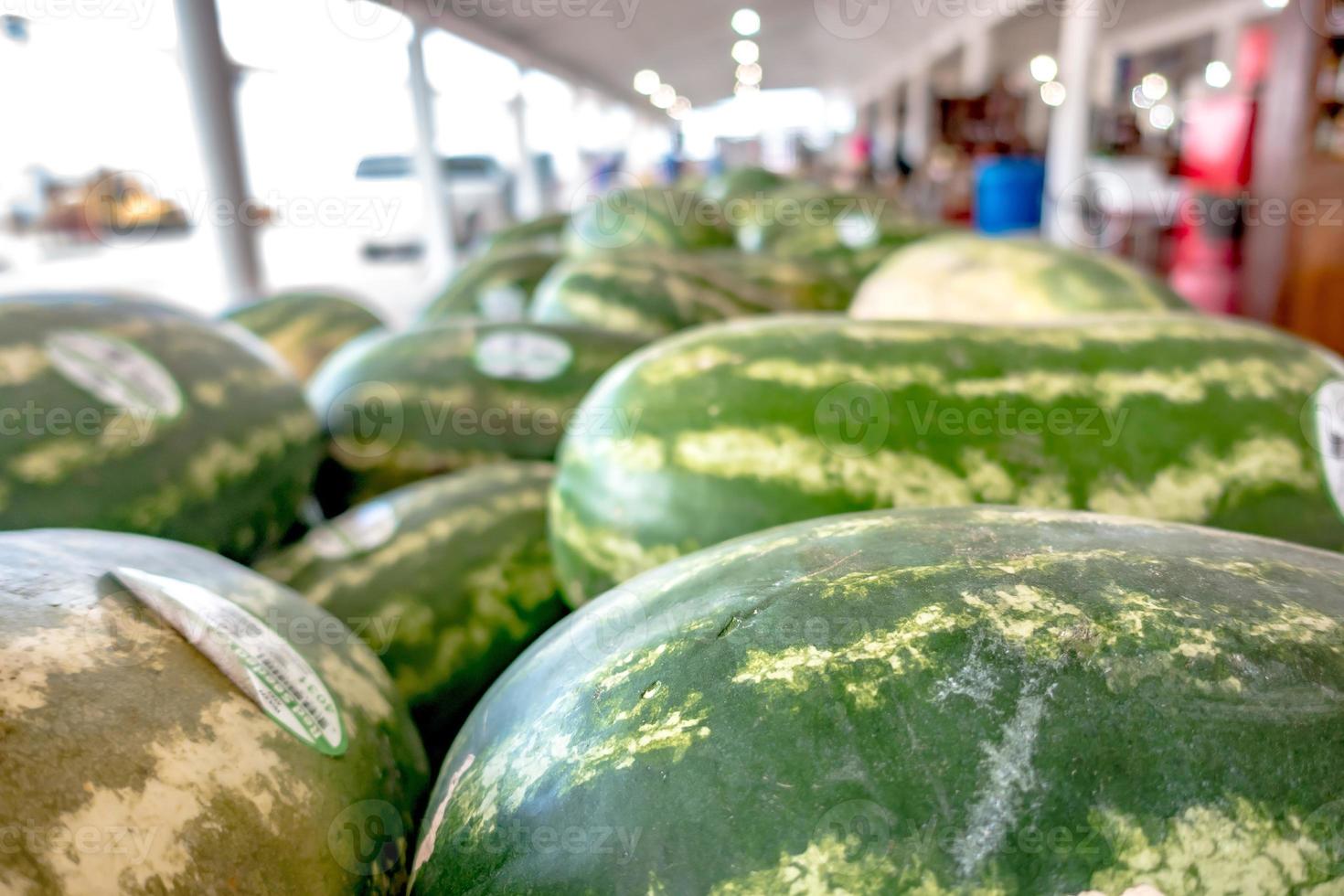 Haufen frischer reifer Wassermelonen, die in Holzkisten in Obst liegen lying foto