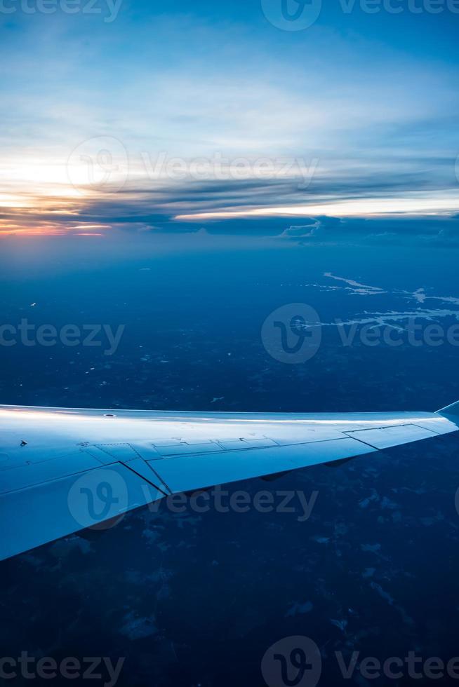Blick auf den Sonnenuntergang aus dem Flugzeugfenster foto