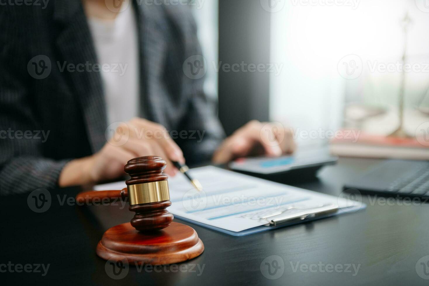 Gerechtigkeit und Gesetz konzept.recht Thema hölzern Schreibtisch, Bücher, Gleichgewicht. männlich Richter im ein Gerichtssaal das Hammer, funktioniert mit Digital Tablette Computer auf Tabelle foto