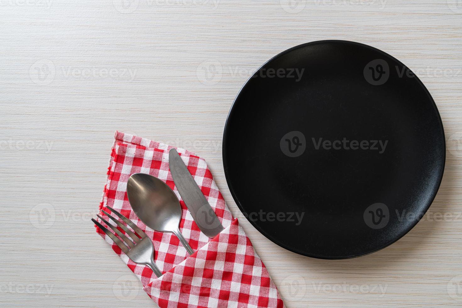 leerer Teller oder Teller mit Messer, Gabel und Löffel auf Holzfliesenhintergrund foto