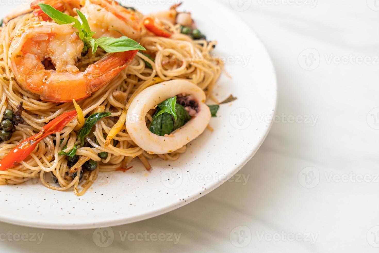 gebratene chinesische Nudeln mit Basilikum, Chili, Garnelen und Tintenfisch - asiatische Küche foto