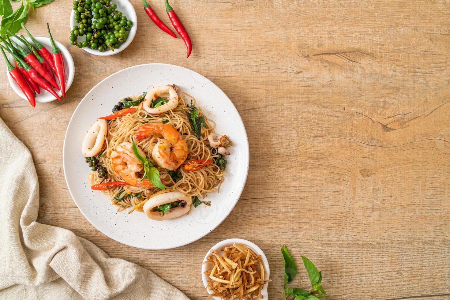 gebratene chinesische Nudeln mit Basilikum, Chili, Garnelen und Tintenfisch - asiatische Küche foto