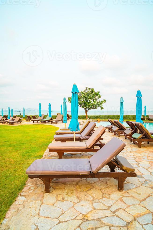 Liegepool oder Bettpool und Sonnenschirm um den Pool mit Meeresstrandhintergrund in Pattaya in Thailand foto