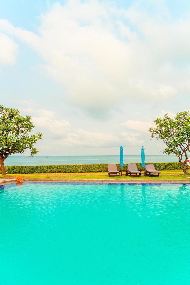 Liegepool und Sonnenschirm rund um den Pool mit Ozean-Meer-Hintergrund foto