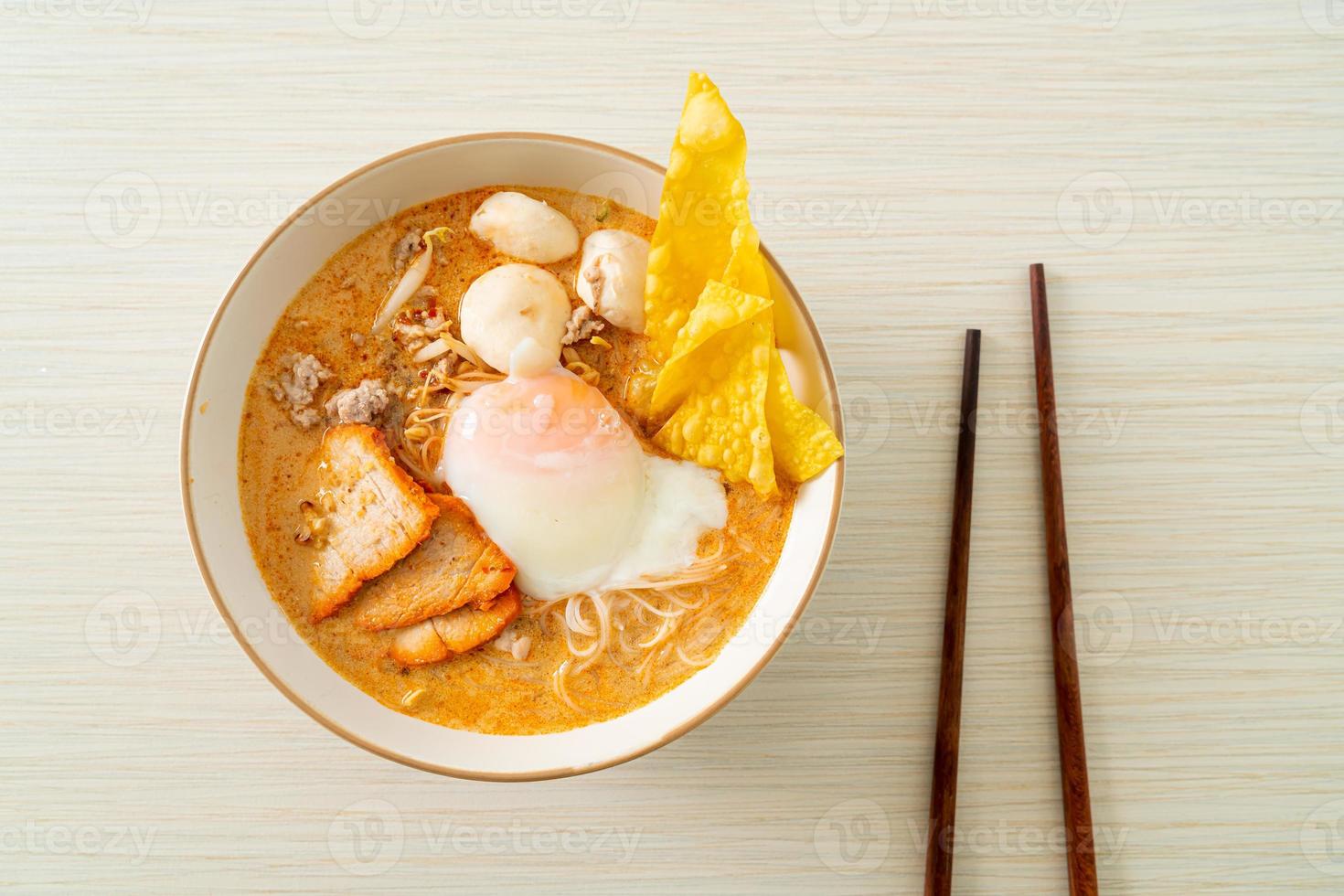 Reisfadennudeln mit Frikadellen, gebratenem Schweinefleisch und Ei in scharfer Suppe foto