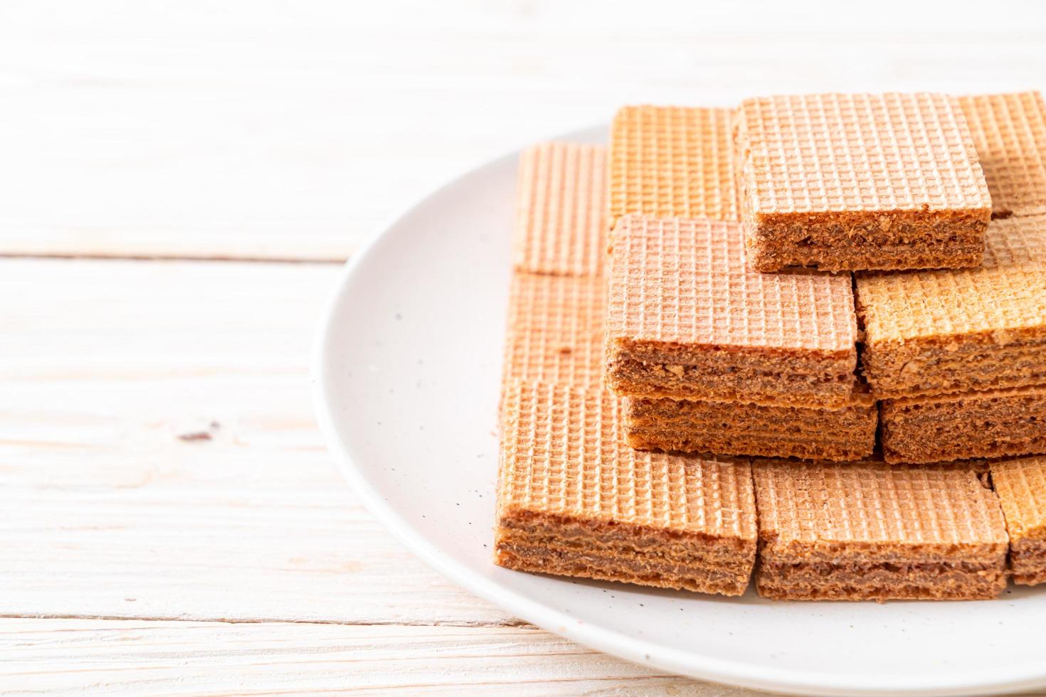 Schokoladenwaffeln mit Schokoladencreme auf Holzhintergrund foto