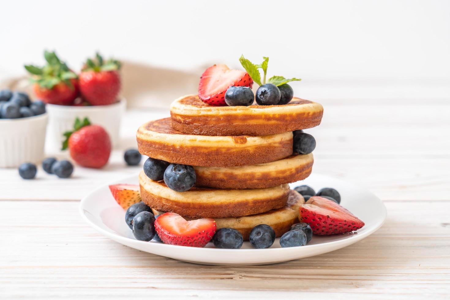 Souffle Pancake mit frischen Blaubeeren, frischen Erdbeeren und Honig foto