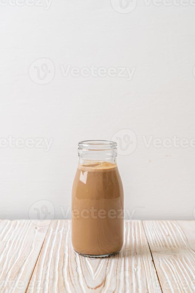 Kaffee mit Milch in der Flasche auf Holzhintergrund foto