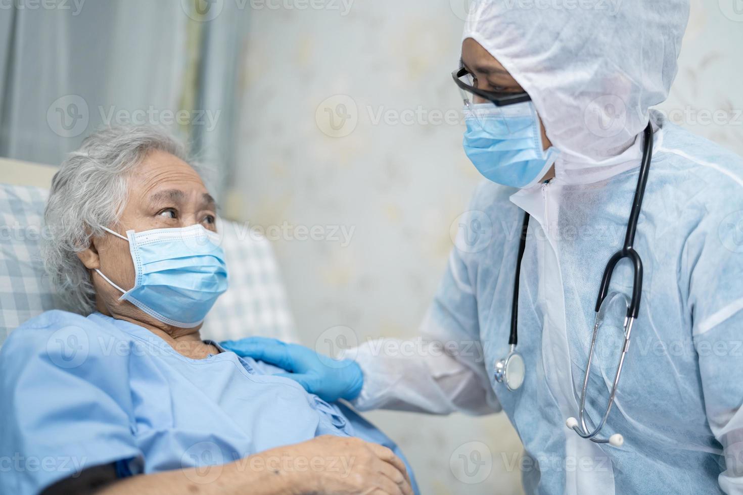 Arzt, der ein Stethoskop verwendet, um asiatische Senioren oder ältere Frauen mit einer Gesichtsmaske im Krankenhaus zu überprüfen, um die Infektion mit dem Covid-19-Coronavirus zu schützen. foto