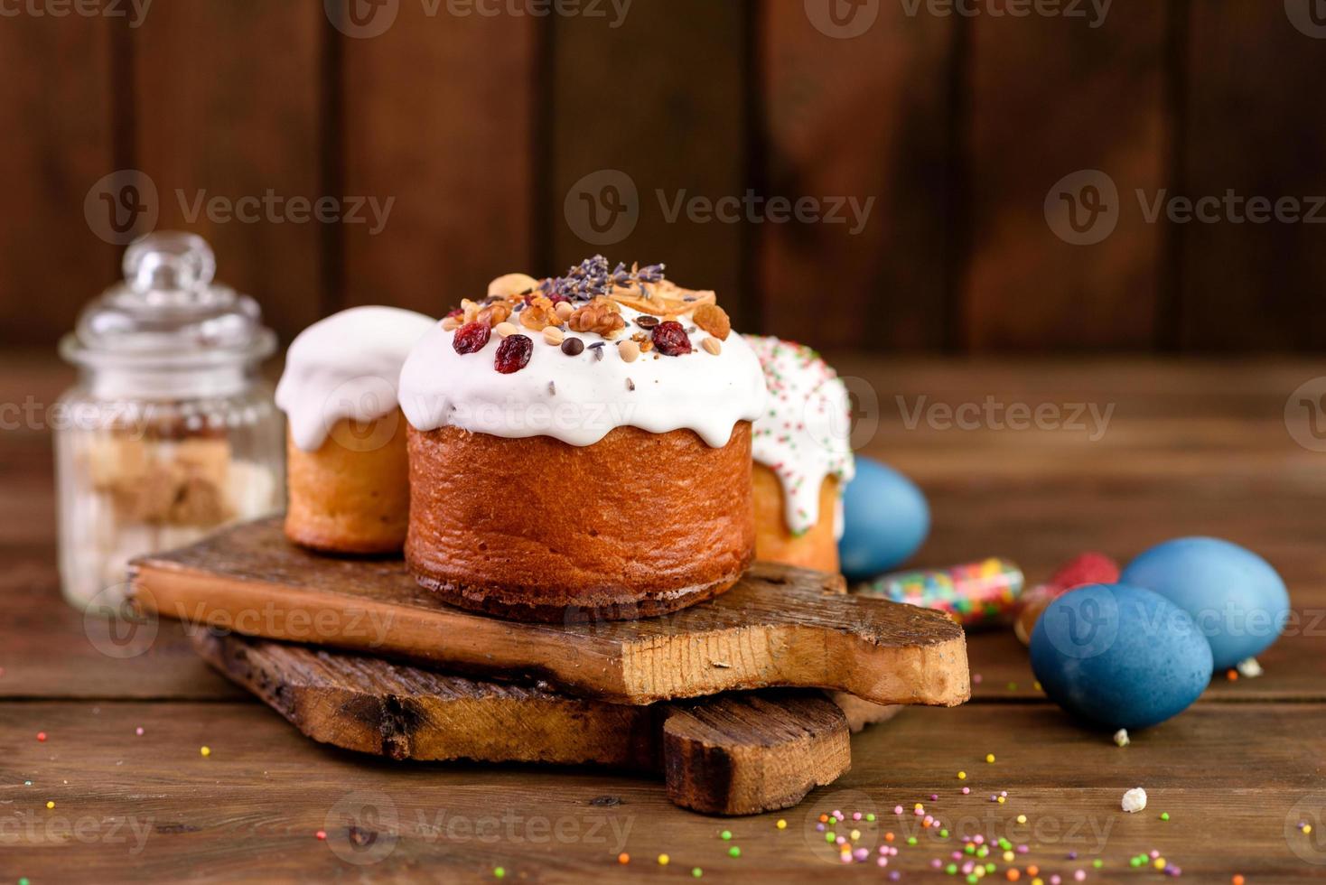 festliche Kuchen mit weißer Glasur, Nüssen und Rosinen mit Ostereiern auf dem festlichen Tisch foto