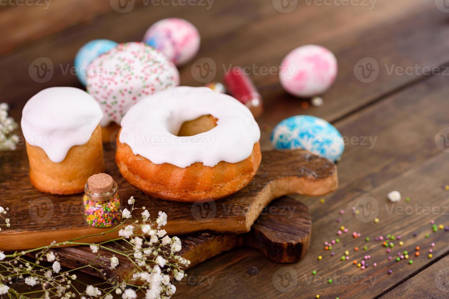 festliche Kuchen mit weißer Glasur, Nüssen und Rosinen mit Ostereiern auf dem festlichen Tisch foto