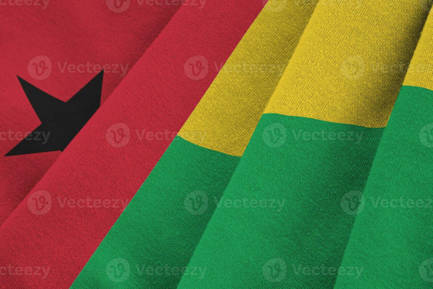 guinea-bissau-flagge mit großen falten, die dicht unter dem studiolicht im innenbereich wehen. die offiziellen symbole und farben im banner foto