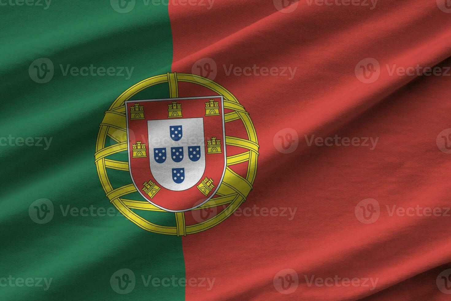portugiesische flagge mit großen falten, die dicht unter dem studiolicht im innenbereich wehen. die offiziellen symbole und farben im banner foto