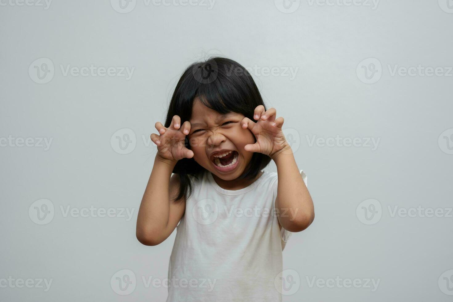 Porträt eines glücklichen und lustigen asiatischen Mädchens auf weißem Hintergrund, ein Kind, das in die Kamera schaut. träumendes vorschulkind füllt sich mit energie, die sich gesund und gut fühlt foto