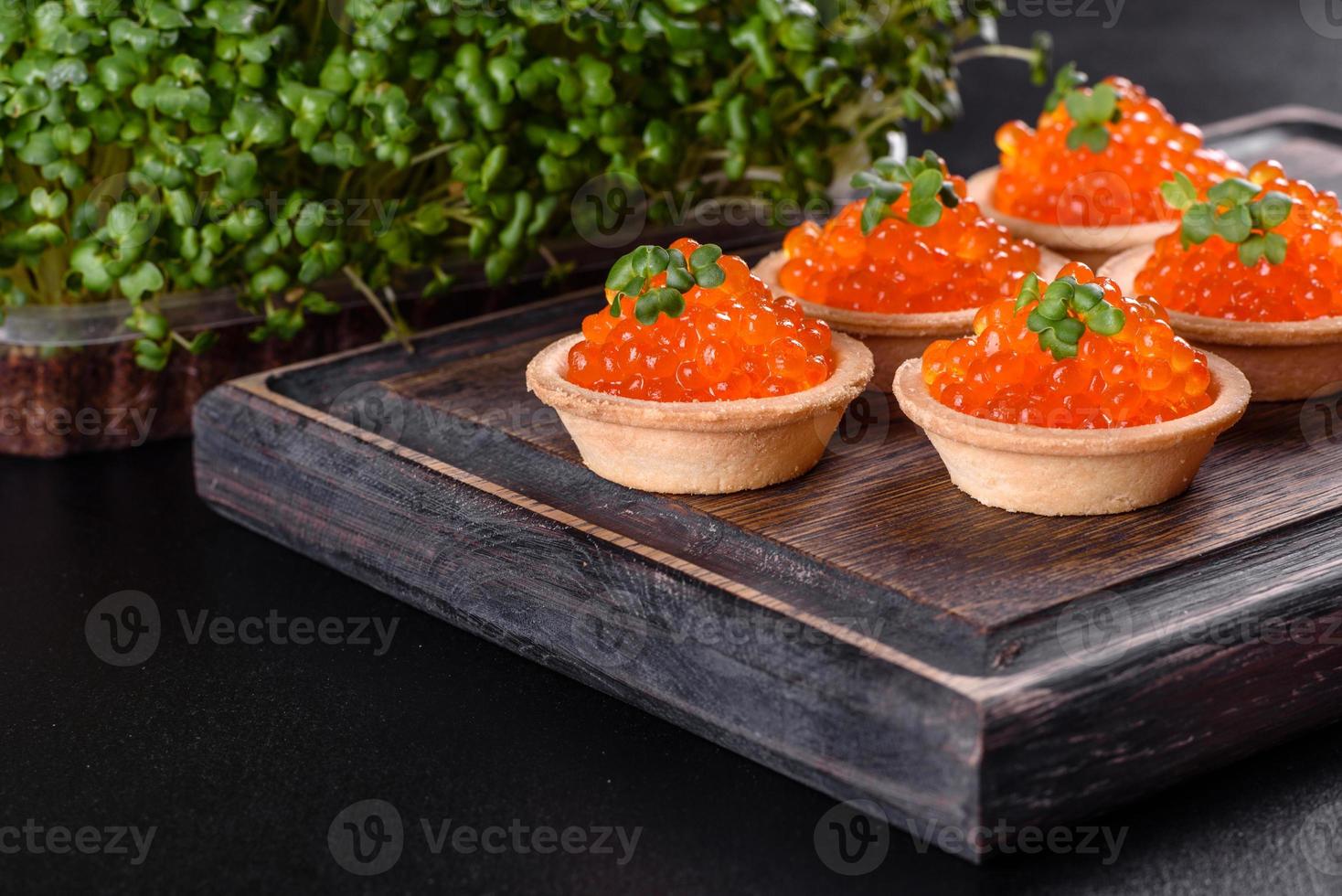 leckerer frischer roter Kaviar auf einem dunklen Betontisch foto