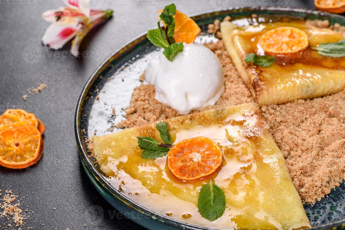 köstliche frische Pfannkuchen auf einem Teller mit süßer Sauce und Eiscreme dekoriert mit Minze foto