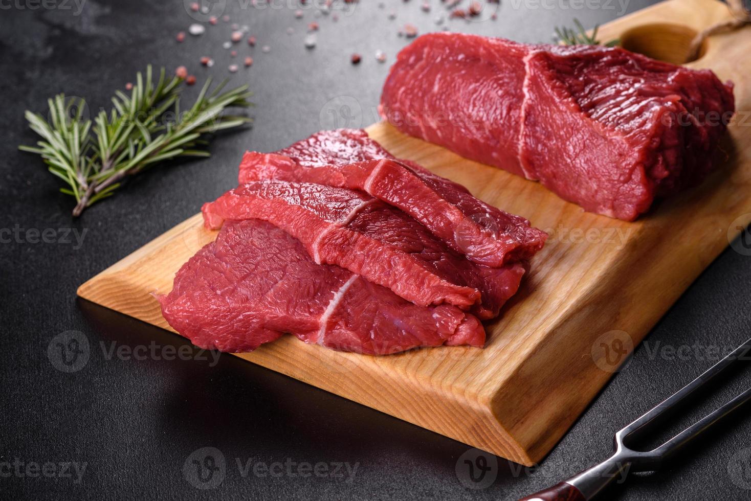 frisches rohes Rindfleisch für ein köstliches saftiges Steak mit Gewürzen und Kräutern foto