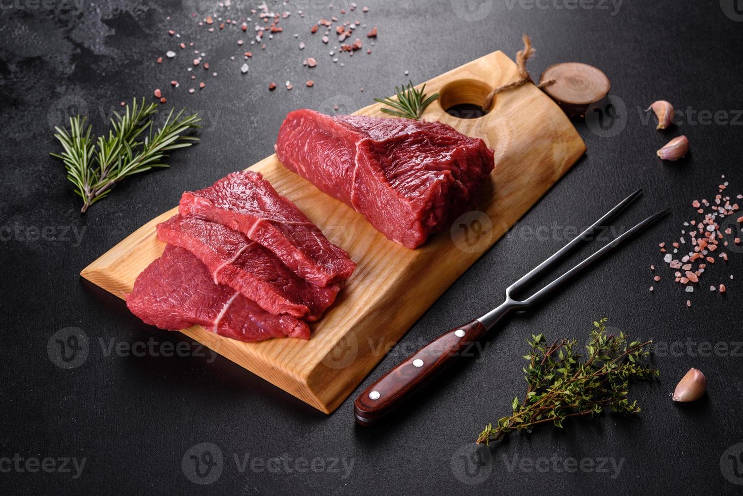 frisches rohes Rindfleisch für ein köstliches saftiges Steak mit Gewürzen und Kräutern foto