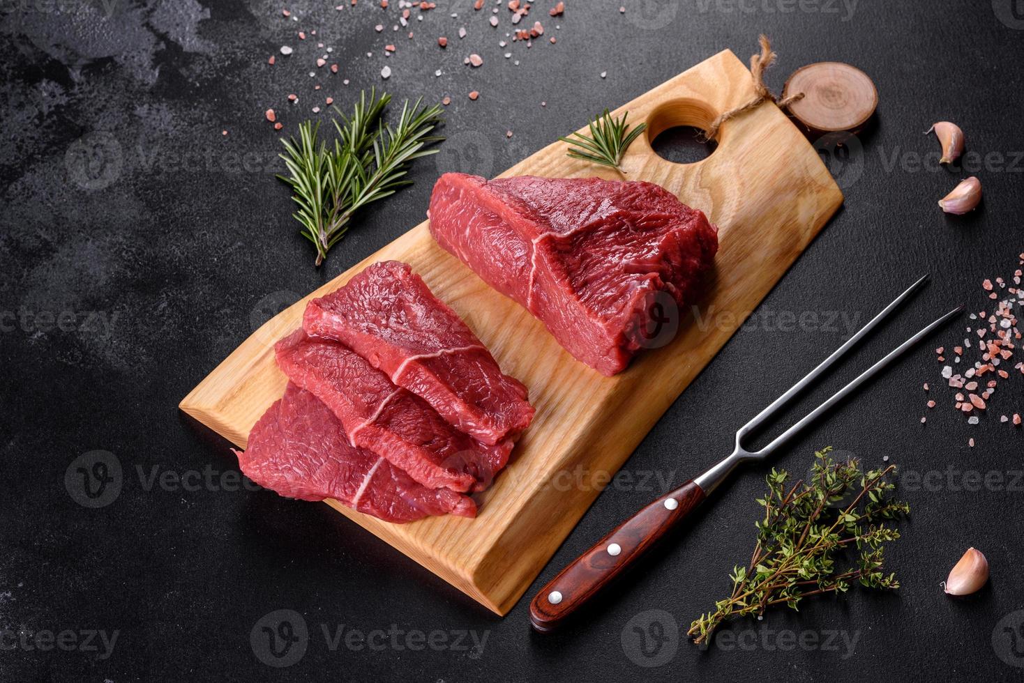 frisches rohes Rindfleisch für ein köstliches saftiges Steak mit Gewürzen und Kräutern foto