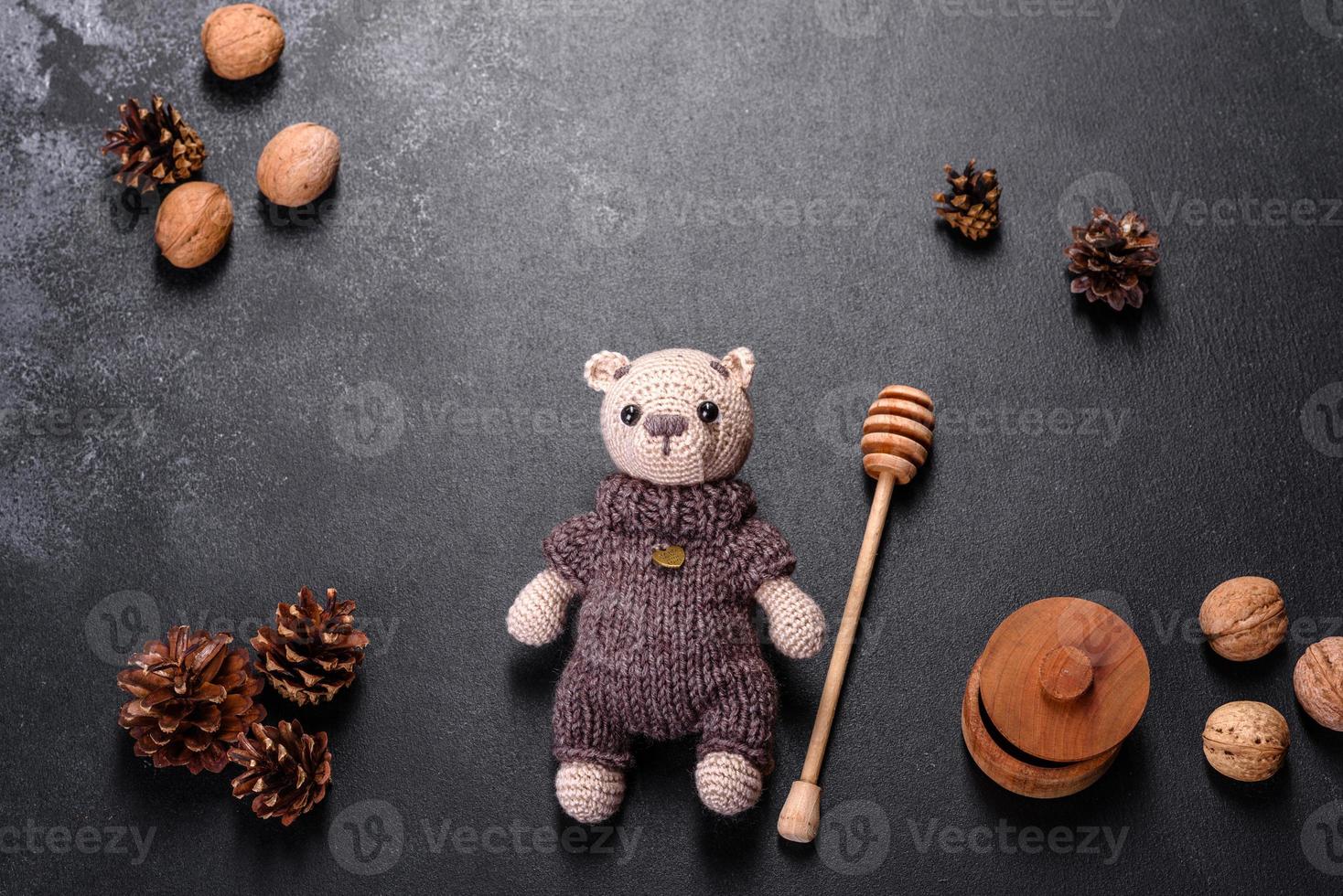 Spielzeugbär aus Wollfäden auf dunklem Hintergrund gebunden foto