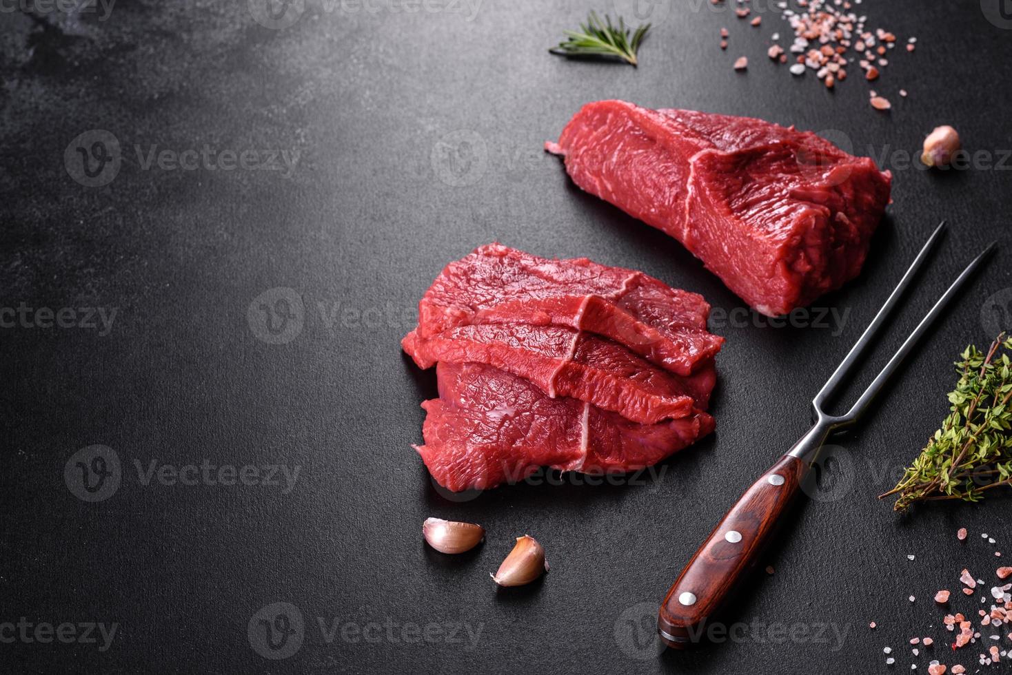 frisches rohes Rindfleisch für ein köstliches saftiges Steak mit Gewürzen und Kräutern foto