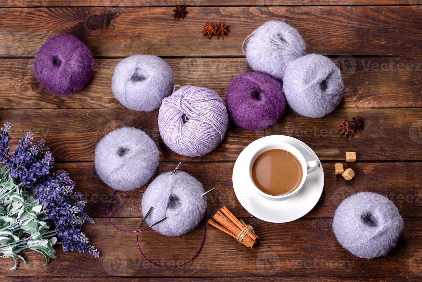 Gewirr von Wollfäden und Speichen mit einer Tasse Kaffee und Zucker auf einem hölzernen Hintergrund foto