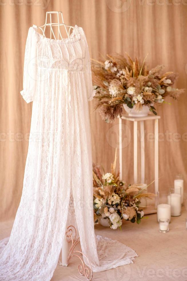 Dekorationen aus trockenen schönen Blumen in einer weißen Vase auf einem beigen Stoffhintergrund foto