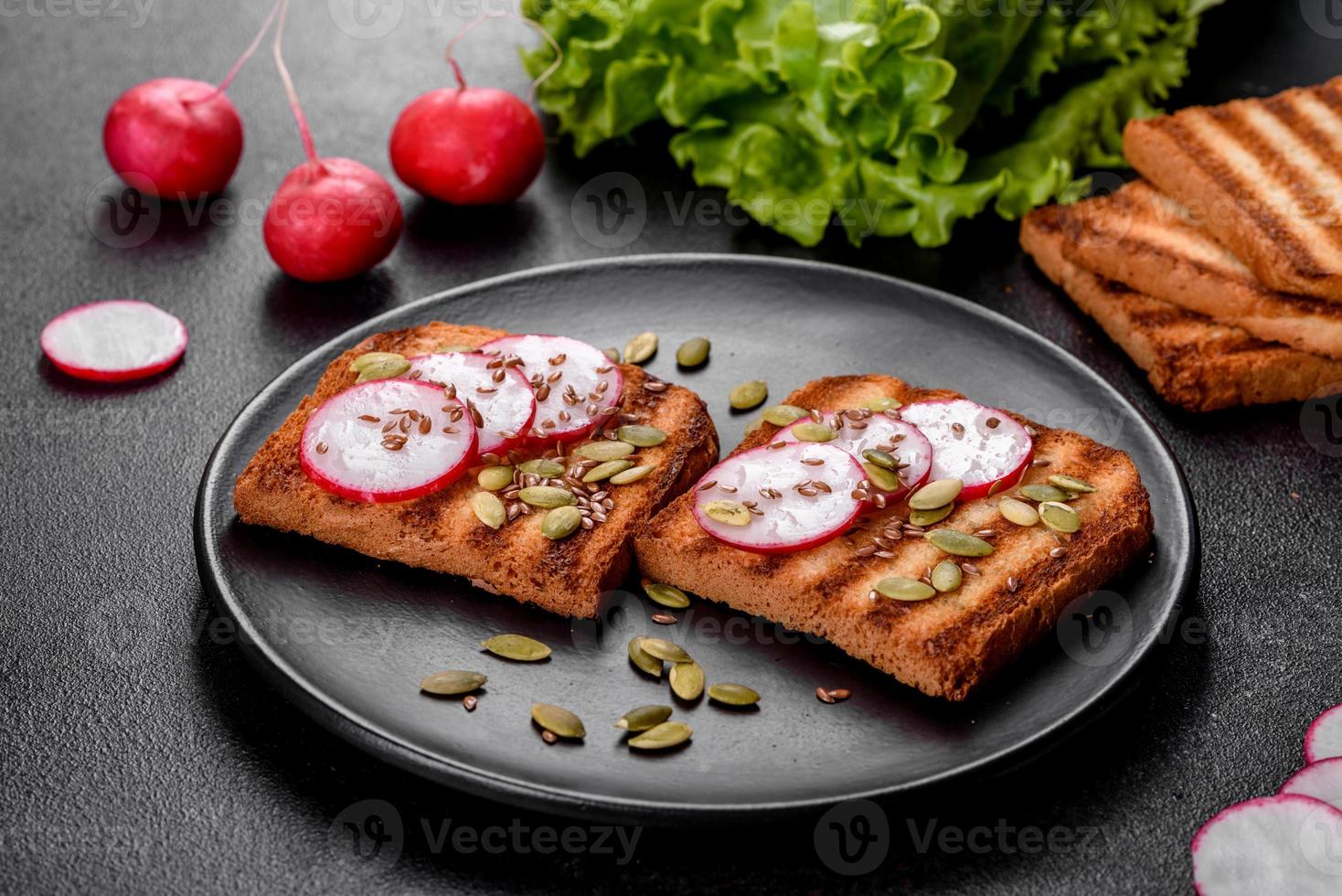leckeres knuspriges Sandwich mit Toast, Rettich, Kürbiskernen und Leinsamen foto