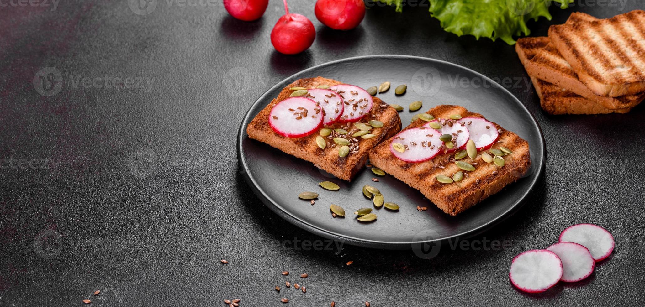 leckeres knuspriges Sandwich mit Toast, Rettich, Kürbiskernen und Leinsamen foto