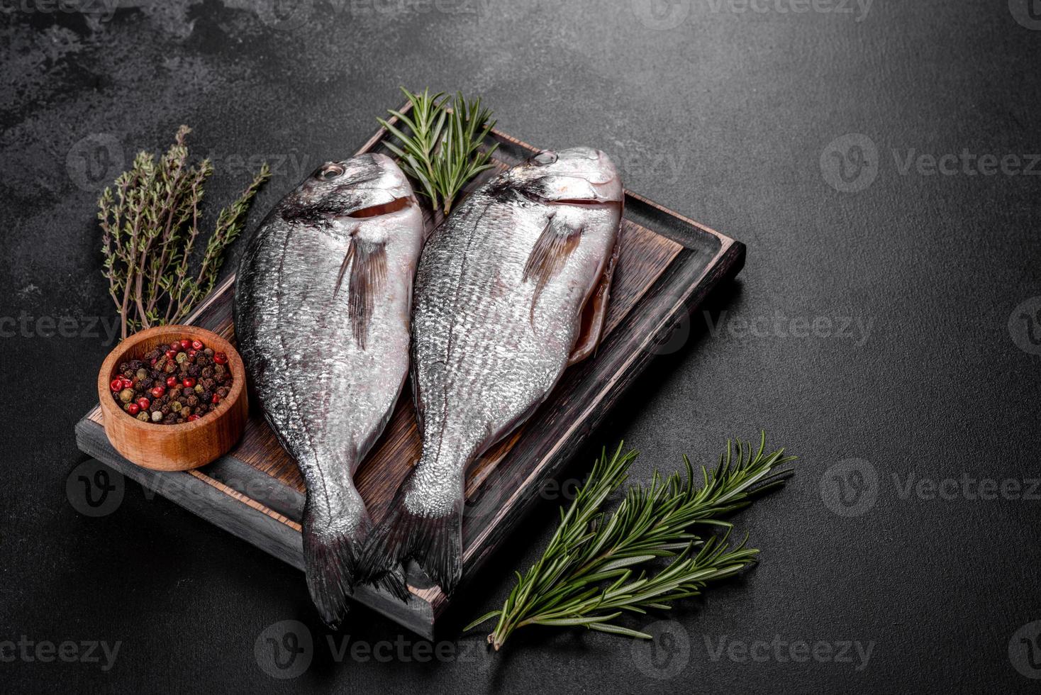 roher Dorado-Fisch mit Gewürzen, die auf Schneidebrett kochen. frischer Fisch Dorado foto