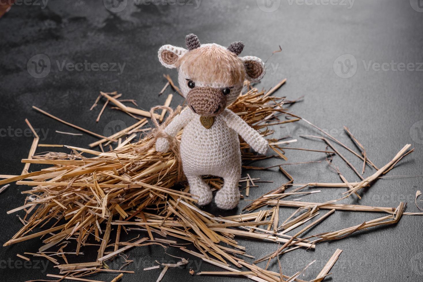 gestrickter Spielzeugbulle aus hellen Fäden auf dunklem Hintergrund foto