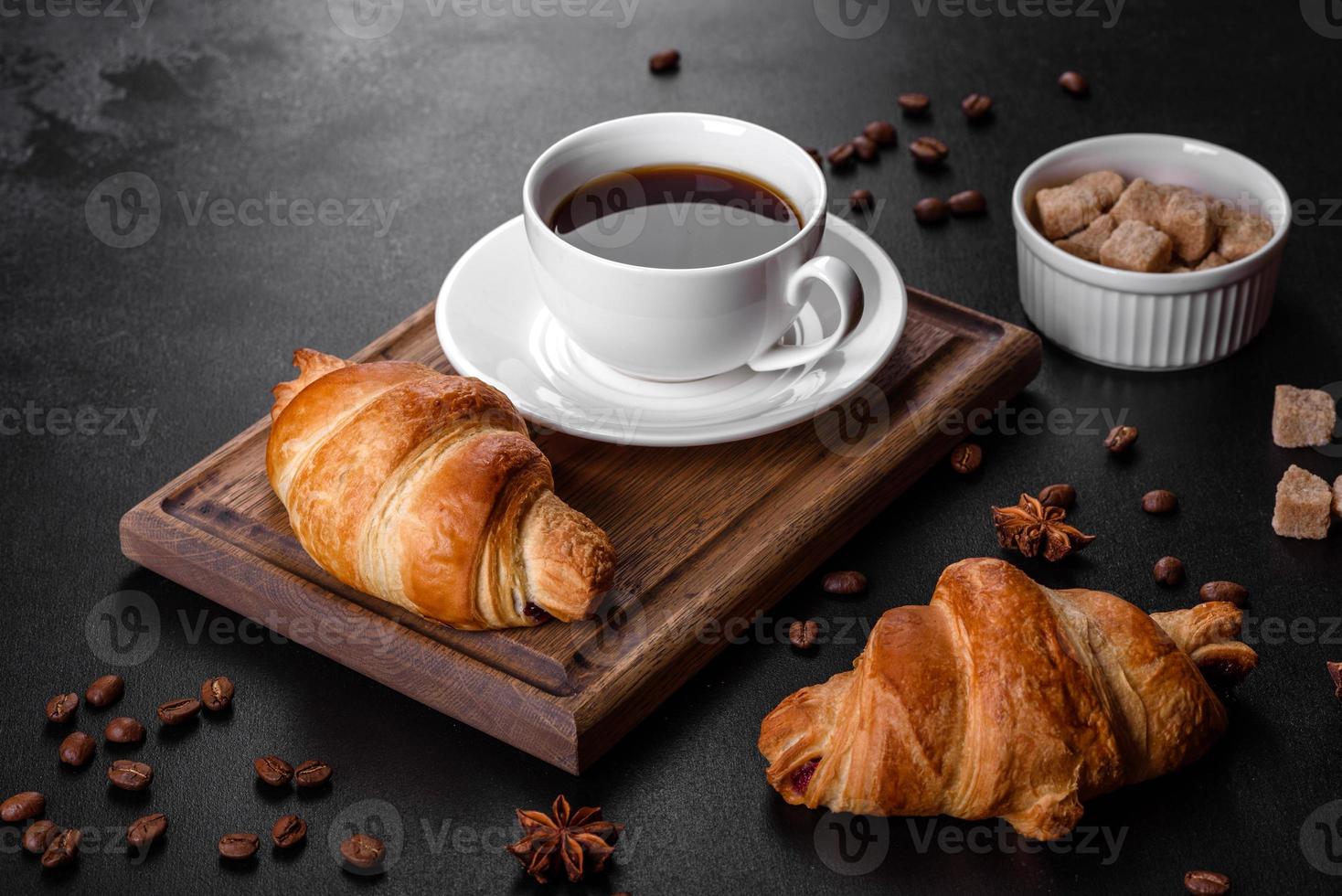 frisches knackiges leckeres französisches Croissant mit einer Tasse duftendem Kaffee foto